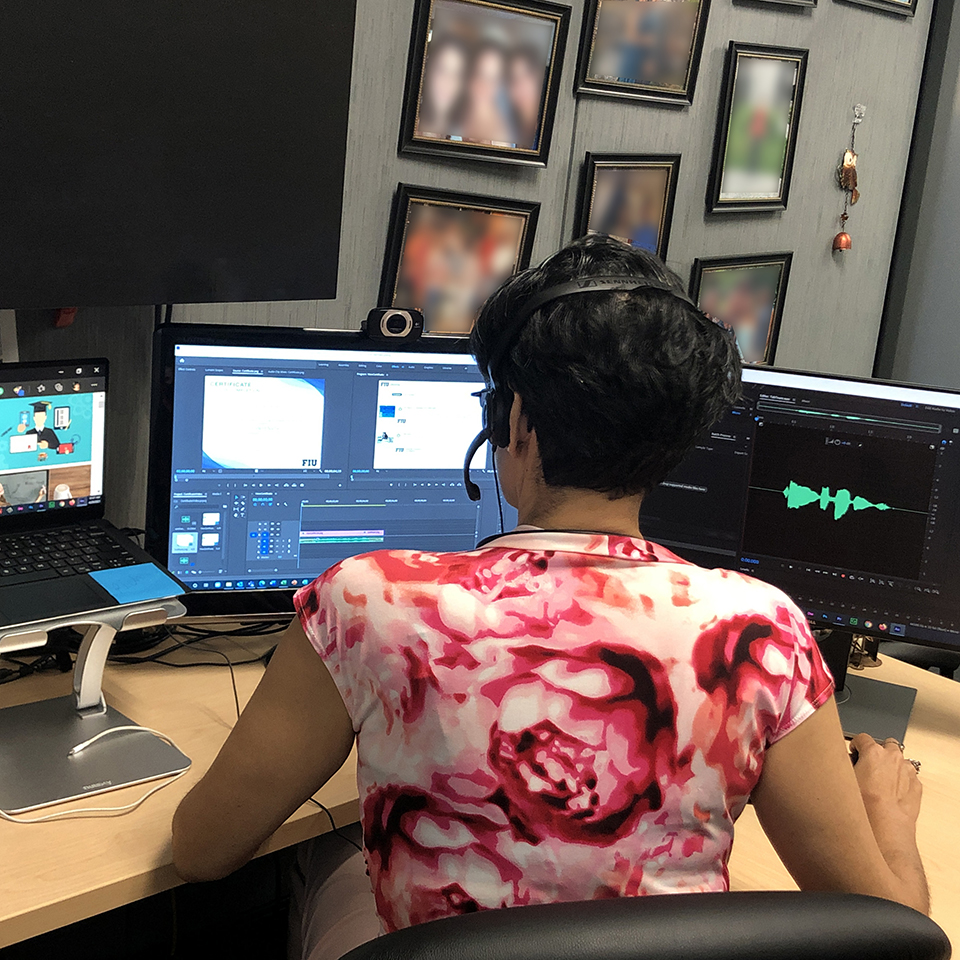 Brenda working on multimedia production in her computer with 3 monitors